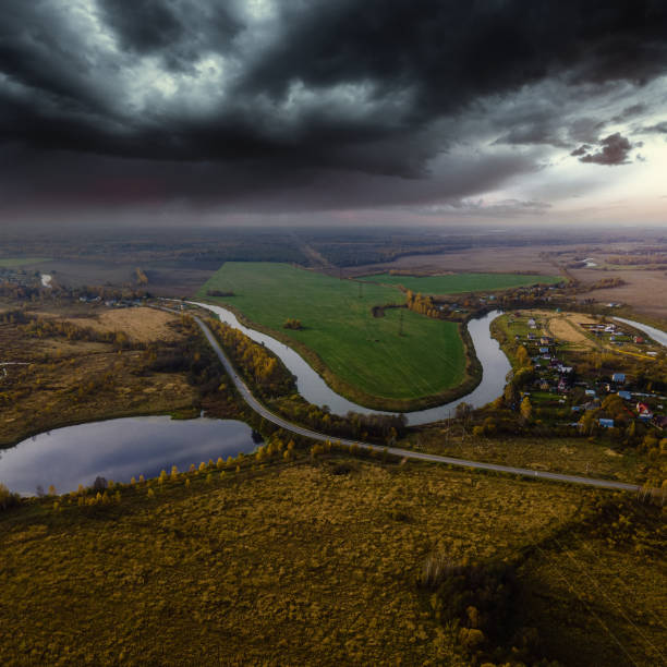 Country road in fields against stormy clouds