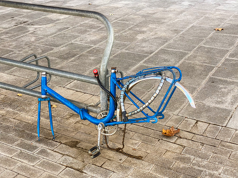 Valencia, Spain - October 17, 2020: Bicycle hooked to pole with missing rear wheel. Most likely the owner left it there and took the wheels to fix them