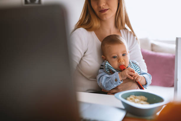 istock Mother feeding baby at home office with bananas 1282907869