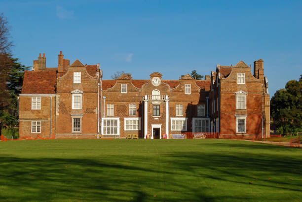Hylands House estate natural public parkland. Mansion house villa front view with grass lawn Ha Ha Wall. Georgian queen Anne style Palladian stately home  Outdoors on a sunny autumn winter day. Chelmsford, Essex, United Kingdom, November 22, 2020