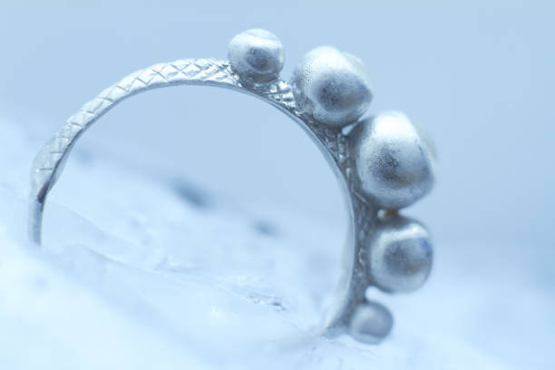 istock Close-up silver ring frozen into ice on white background, selective focus 1282908034