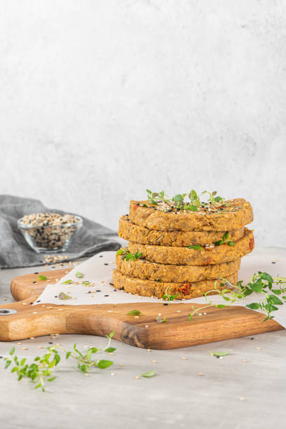 istock Raw veggie burger with lentils, vegetables and thyme leaves on kitchen countertop. 1282910502