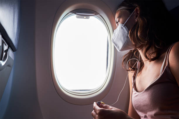 istock young girl wearing face mask on airplane 1282910849