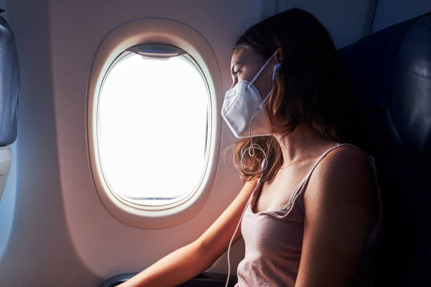 istock young girl wearing face mask on airplane 1282911546