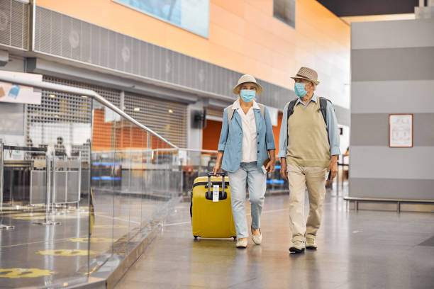 istock Woman with a trolley suitcase and a man walking ahead 1282912882