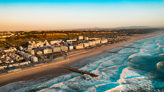The Aerial footage of Costa da Caparica coastline of glorious sandy beaches, powerful Atlantic waves. City near the ocean. High quality photo