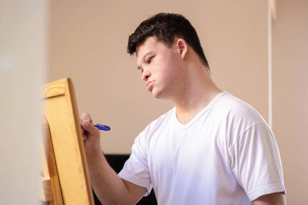 istock Boy with down syndrome painting. 1282923635