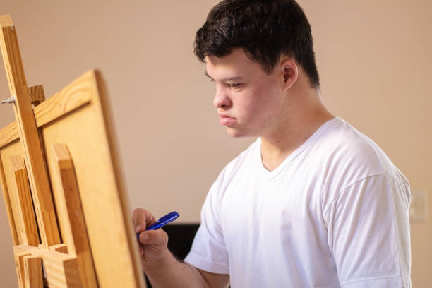 istock Boy with down syndrome painting. 1282923695