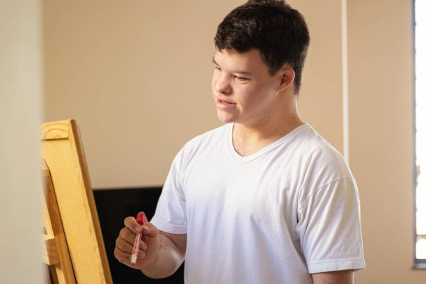 istock Boy with down syndrome painting. 1282924540