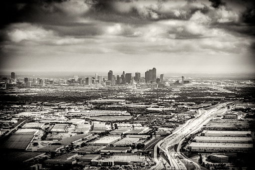 The distant downtown skyline of beautiful Dallas, Texas in black and white and toned for a retro feel in sepia.