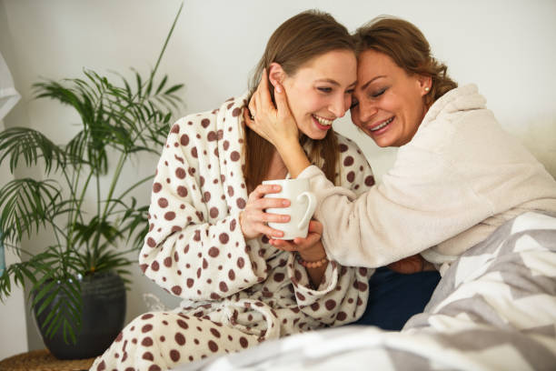 istock Mother and daughter cuddling in bed while enjoying their morning coffee 1282928207