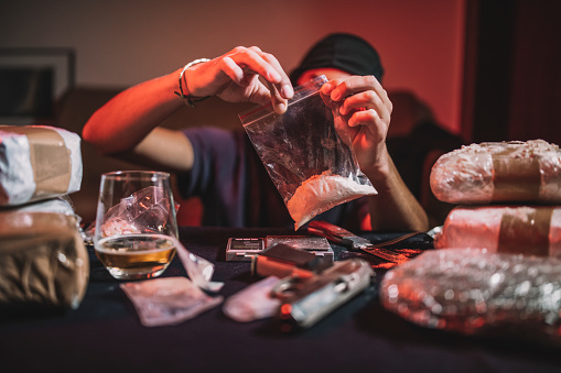 Depressed businessman looking at whisky glasses in a pub