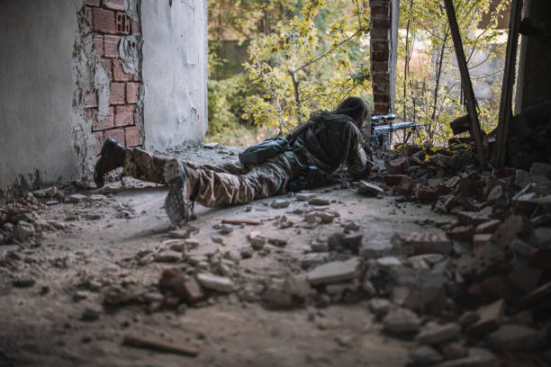 istock Hidden soldier with rifle sniper in building. 1282928269