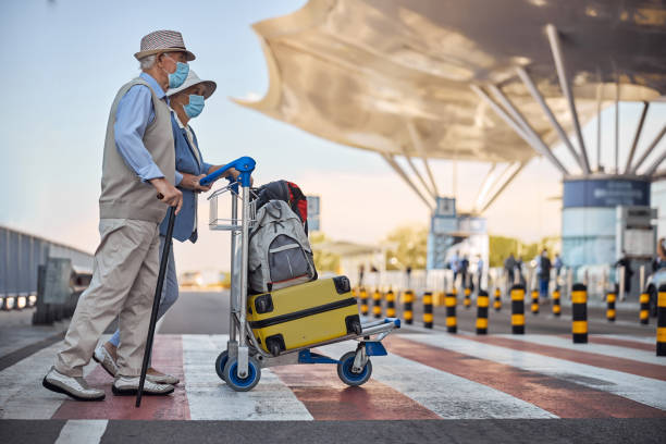 istock Two elderly tourists walking across the street 1282932732