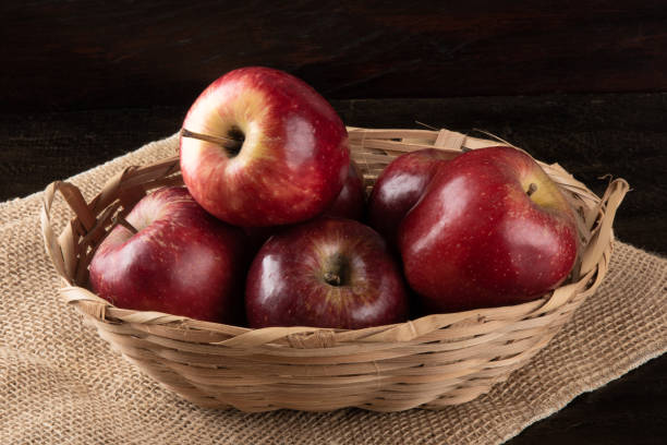 istock Red apples in basket with wooden background 1282936294