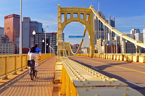 Pittsburgh, PA, USA May 6 A young adult man bikes to work on the Roberto Clemente Bridge in Pittsburgh, Pennsylvania