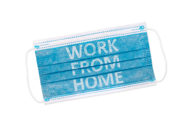 istock Protective face mask isolated on white background with inscription WORK FROM HOME . Coronavirus outbreak around the world 1282945936