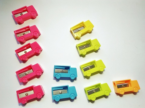 Toy plastic little cars on a light yellowish background with a place for text. Toys for children.
