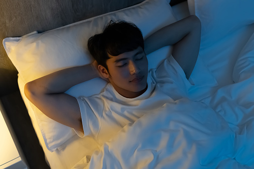 top view of asian man sleep well with smile at night