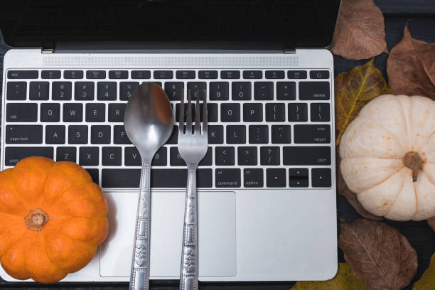 istock Fall Thanksgiving and Halloween pumpkins, dry leaves and have laptop computer 1282958105