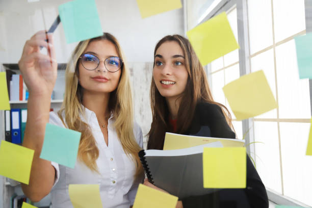 istock Two businesswomen looking at sticky notes 1282960256