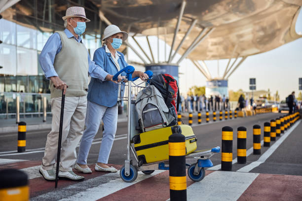 istock Aged tourists wheeling a trolley with their luggage 1282962420
