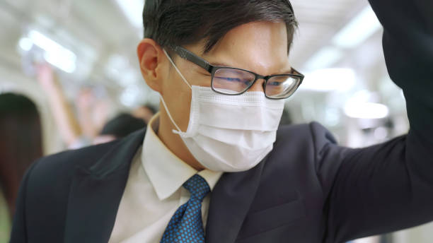 istock Young man wearing face mask travels on crowded subway train 1282964577