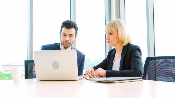 istock Two business people talk project strategy at office 1282968058
