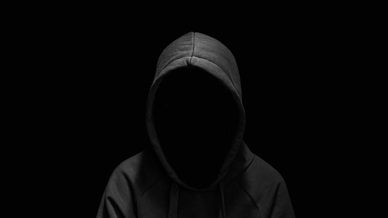 Hooded incognito silhouette isolated and hacker on black background. Internet crime, cyber attack security concept.