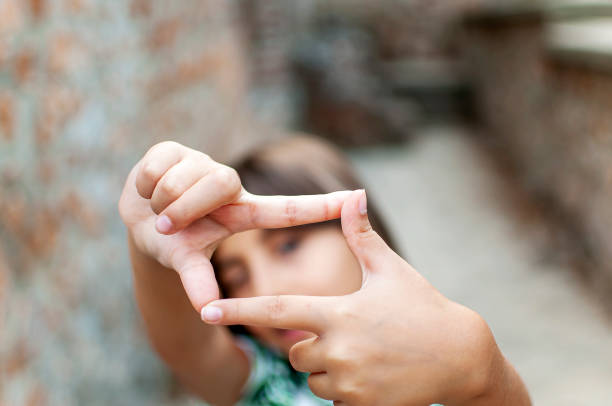 mani cornice fotografica con bambina - imagination creativity finger frame frame foto e immagini stock