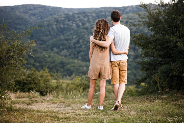 istock Back view of an embraced couple standing on a hill. 1282971423