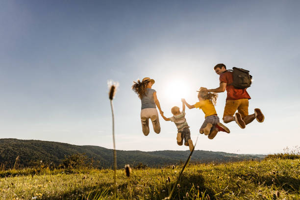 istock Back view of playful family having fun while jumping in nature. 1282972081