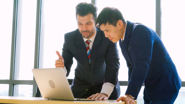 istock Two business people talk project strategy at office 1282972731
