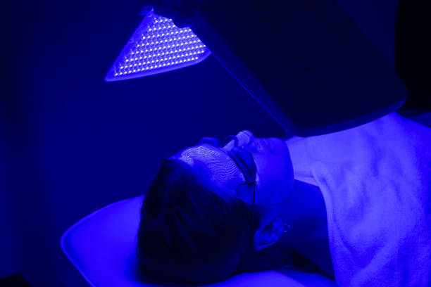 Young woman having blue LED light facial therapy treatment in beauty salon. Beauty and wellness Young woman having blue LED light facial therapy treatment in beauty salon. Beauty and wellness concept environmental regeneration photos stock pictures, royalty-free photos & images