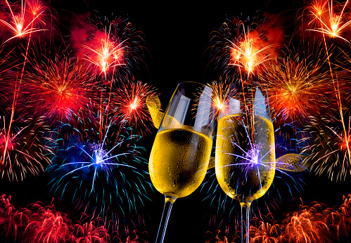 golden champagne glasses with double exposure of fireworks and celebration on a dark background, celebration and festival background concept