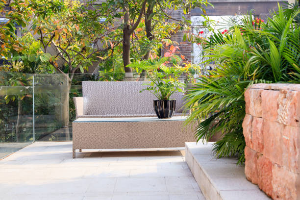 istock Small backyard area with cane chair and table surrounded by evergreen plants in a summer garden 1282973858
