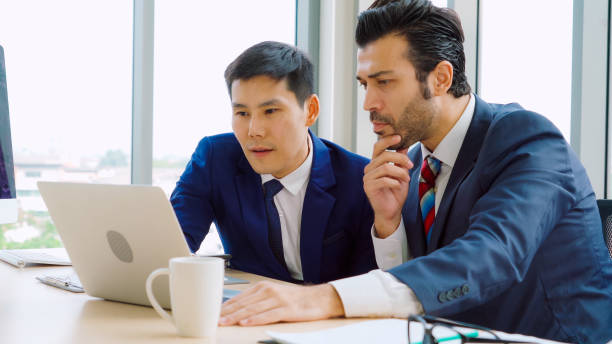 istock Two business people talk project strategy at office 1282974700