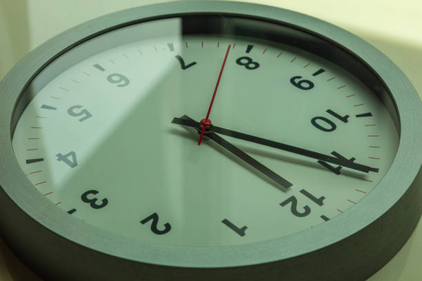 istock Close up to a wall clock, with five minutes to twelve o'clock 1282975625