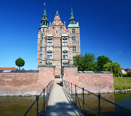 Hillerød, Denmark - August 23, 2022: Neptune fountain in front of the Frederiksborg Castle (c. early 17th century) - the largest Renaissance Castle in Scandinavia.