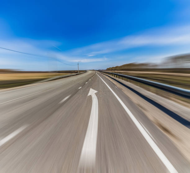 istock View of highway with white arrow sign pointing forward on asphalt 1282975708