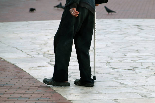 istock an elderly poor man walks with a cane down the street in dirty clothes, bottom view 1282975731