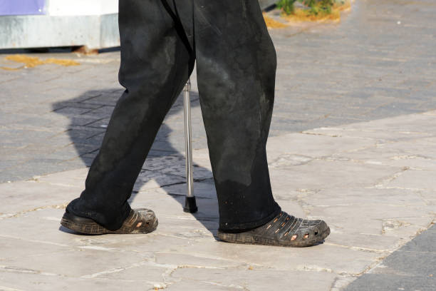 istock an elderly poor man walks with a cane down the street in dirty clothes, bottom view 1282975746