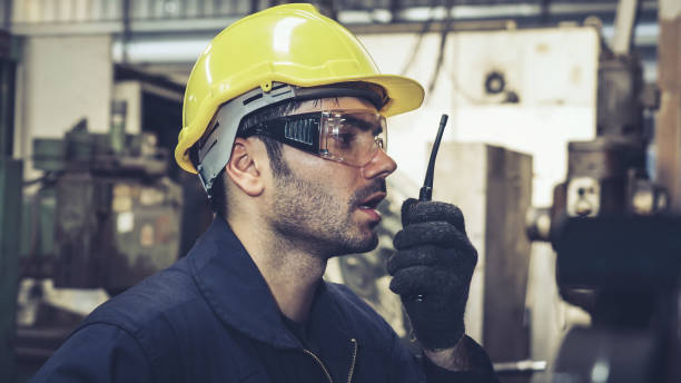 istock Factory worker talking on portable radio while inspecting machinery parts 1282976204