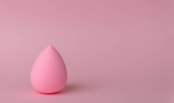 istock A sponge for applying makeup in the form of a drop or egg on a delicate pink background 1282976397