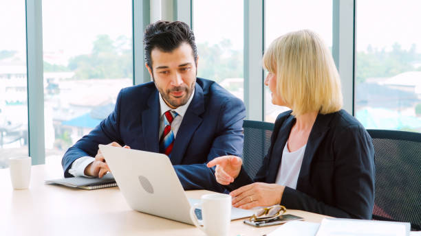 istock Two business people talk project strategy at office 1282977749