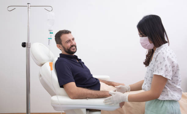 jeune homme recevant le goutte-à-goutte de perfusion de vitamine iv dans l’hôpital ou le salon de beauté. concept de soins de santé, de bien-être et de médecine - infuse photos et images de collection