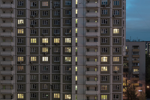 Facade of an apartment building with luminous windows at night