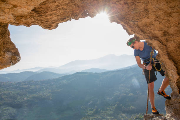 istock Young man climbs in overhanging cave in the morning 1282983137