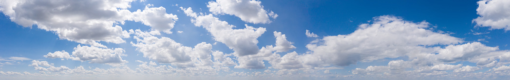 Wide sky panorama with scattered cumulus clouds.