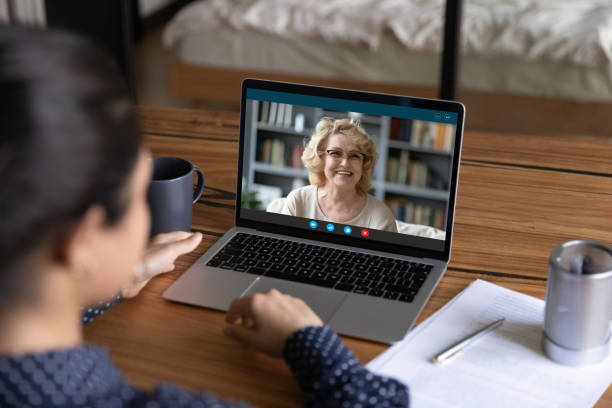 Female employees talk on video call on computer Rear view close up of woman have webcam digital virtual conference on online lesson with mature tutor teacher. Female employee talk speak on video call with middle-aged colleague coworker on web. online tutors stock pictures, royalty-free photos & images